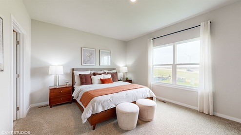 Primary Bedroom with large window and ottoman on edge of bed