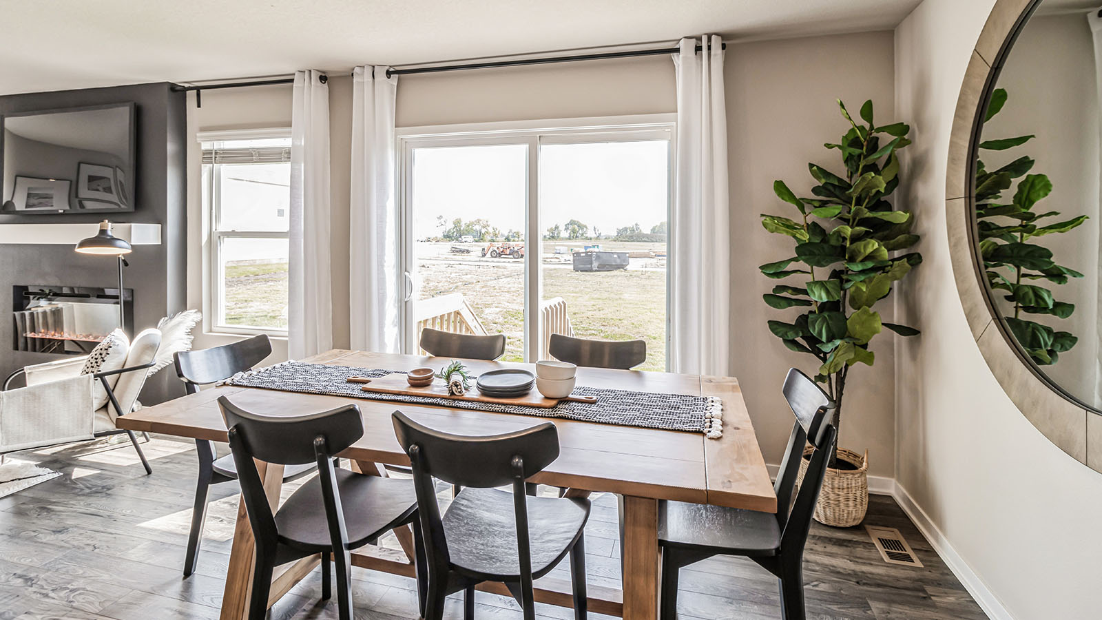 Dining area next to sliding glass doors and living room with black accent wall