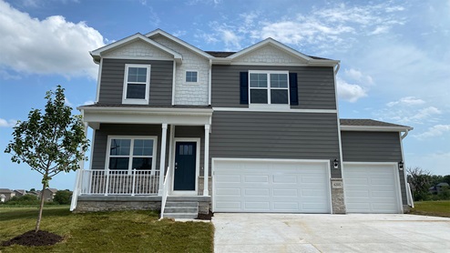 Exterior of the Holland with grey siding, stone and 3 car garage