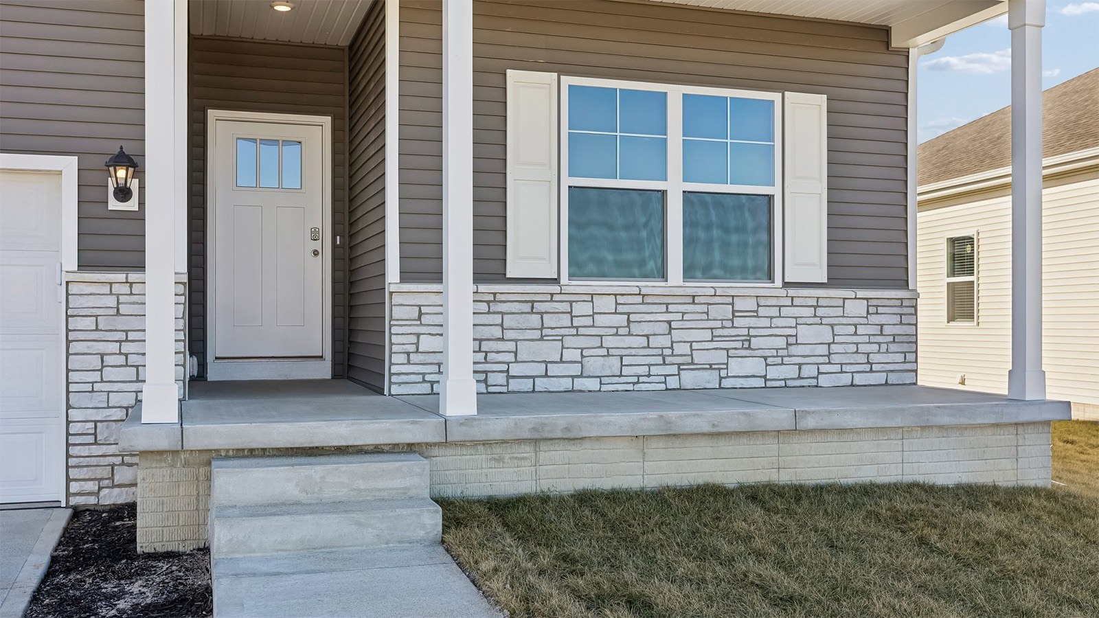 Front porch exterior of home with partial brick siding.
