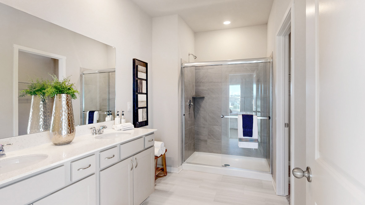 Primary bathroom showing walk in shower dual sinks and walk in closet in the hamilton