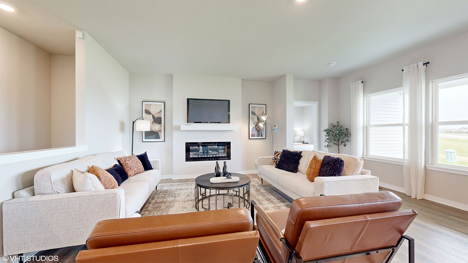 Spacious living room of the Fairfield with two large couches and two chairs around a fireplace