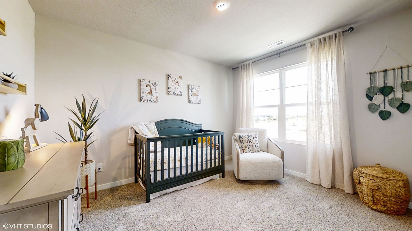 Second bedroom with a crib and rocking chair in the Bellhaven
