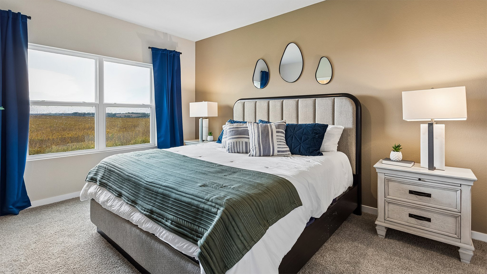 Bright primary bedroom in the Abbott with kind bed and two nightstands