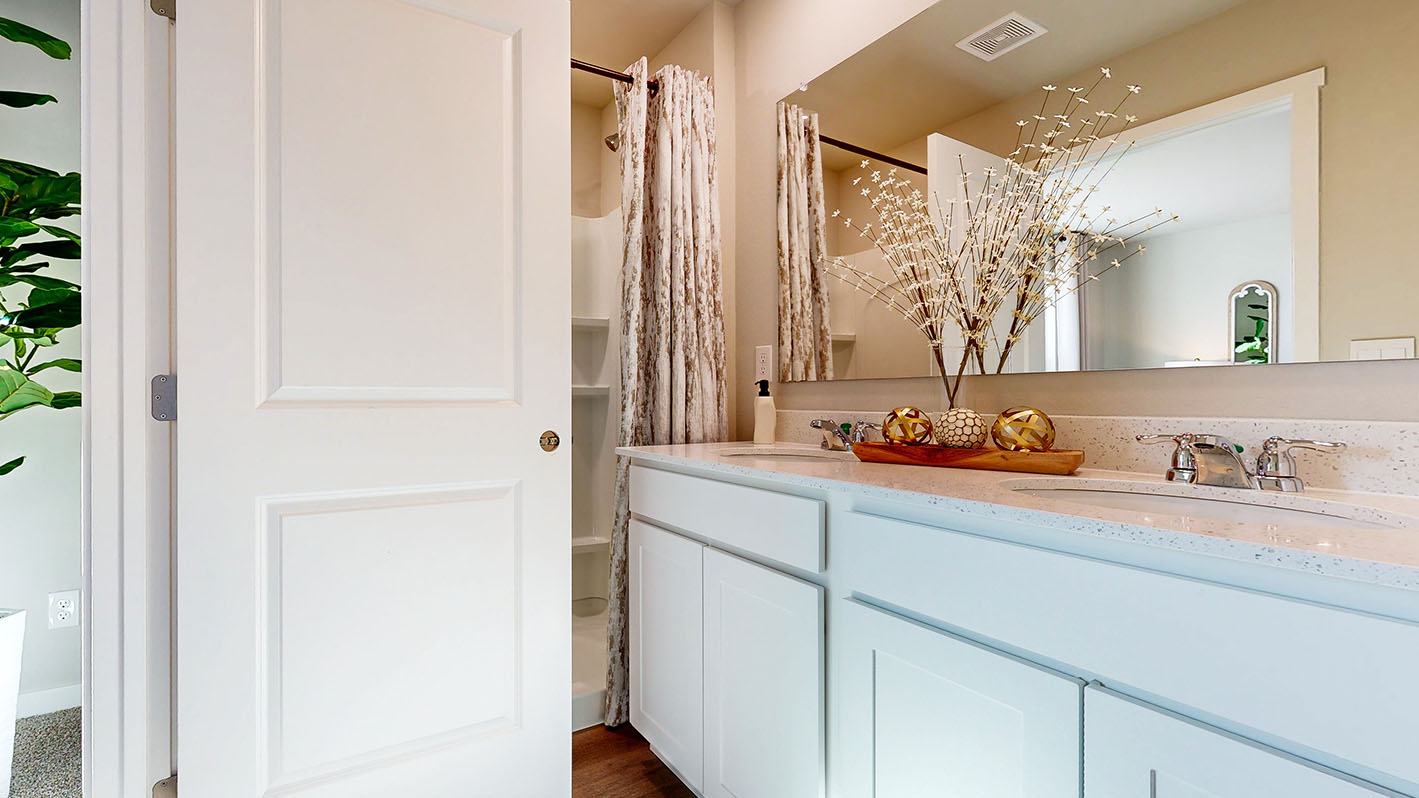 Primary bathroom with dual sinks and walk in shower in the Abbott