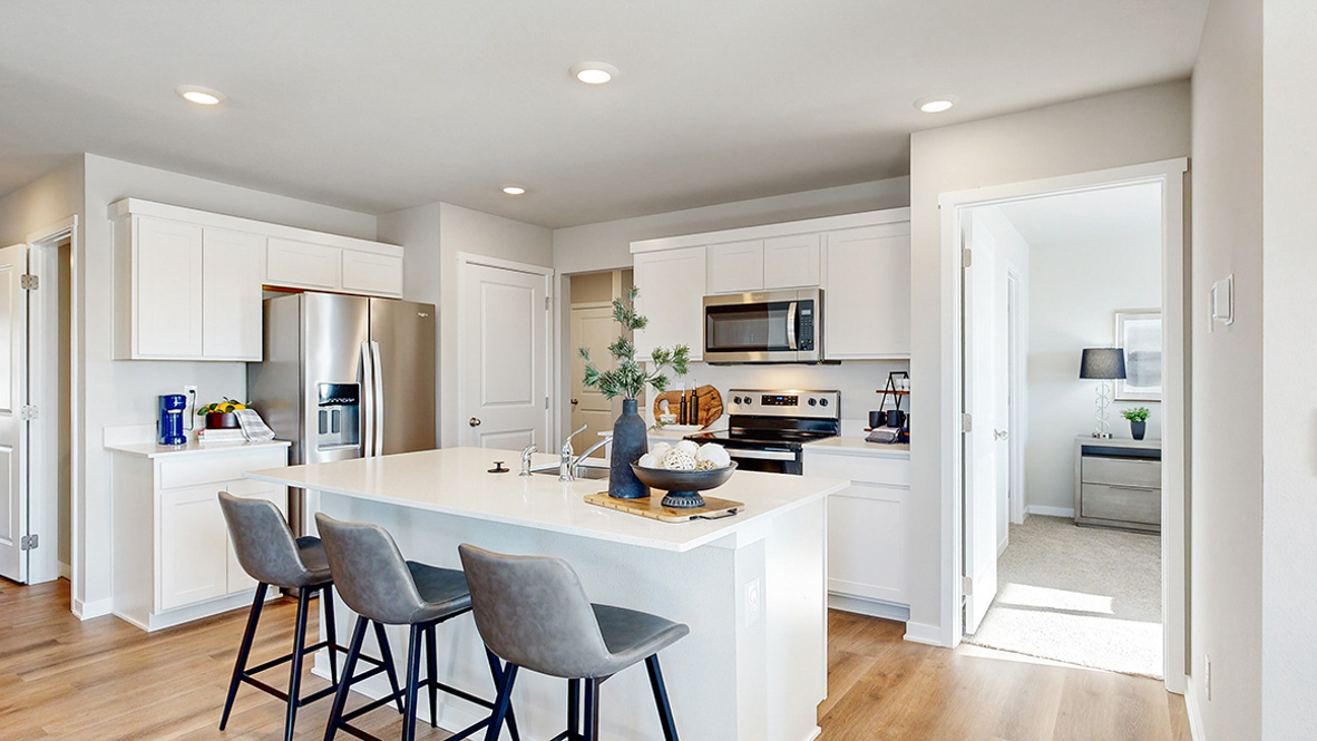 Spacious kitchen showing the entrace to the primary bedroom in the Abbott