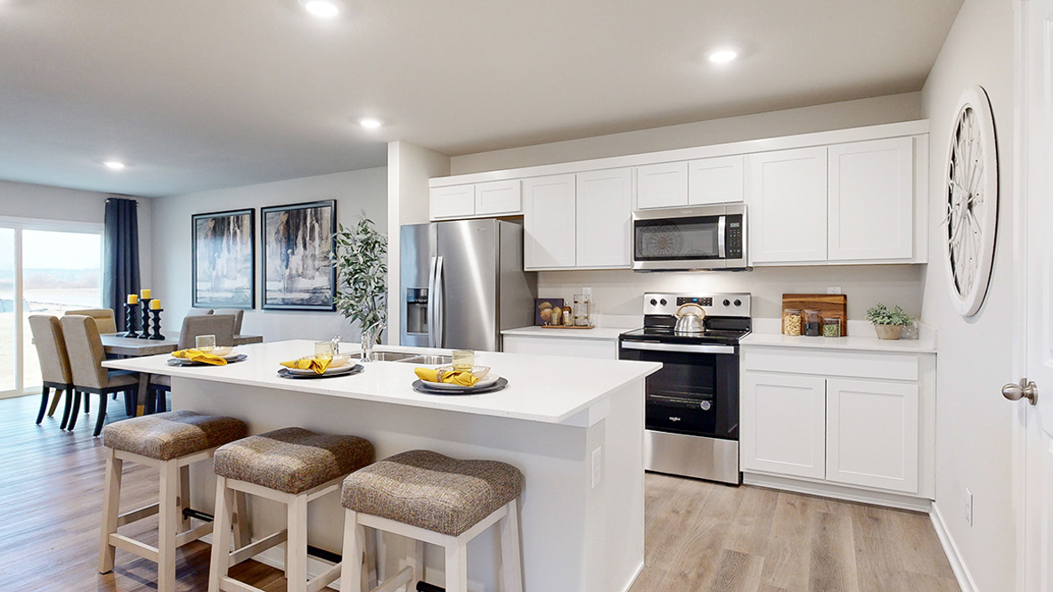 Roland kitchen with white cabinets and island with three chairs