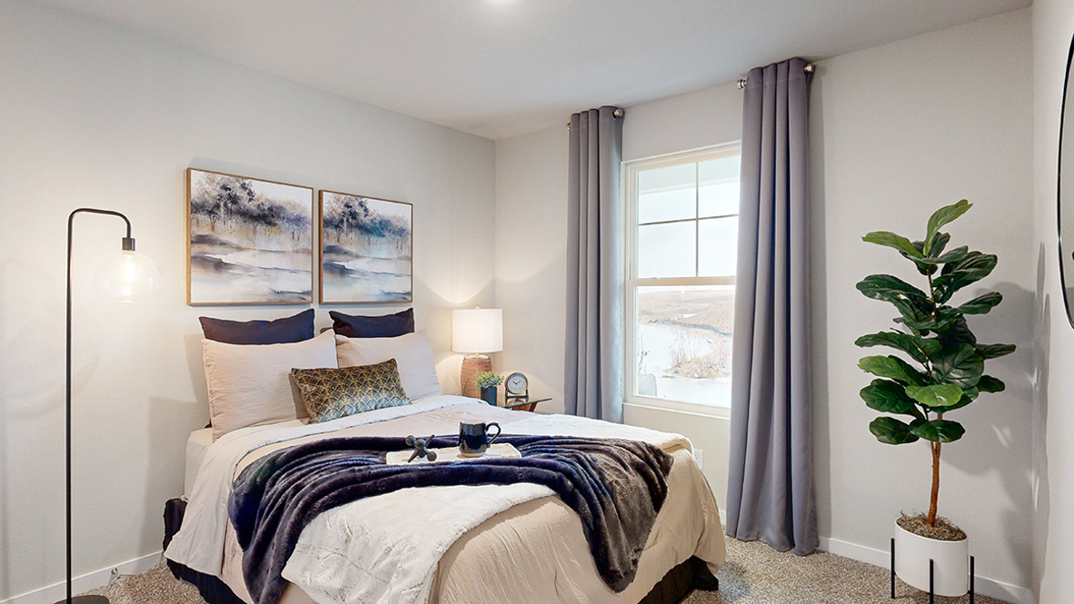 Second bedroom in the Roland with a queen bed and lamp