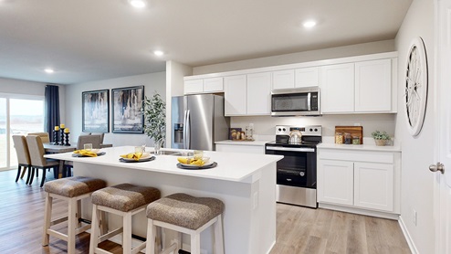 roland kitchen with white cabinets and island with three chairs
