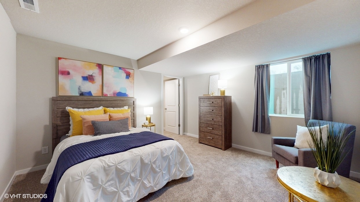 Third bedroom with overhead lighting and white bed