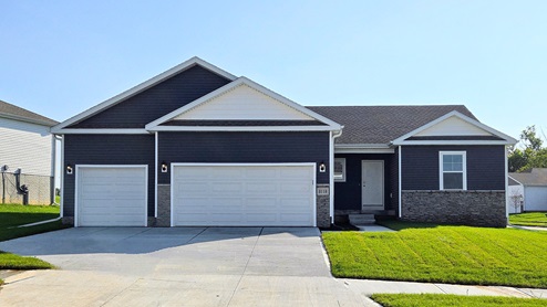 Exterior of the Reagan with midnight blue siding, stone and 3 car garage