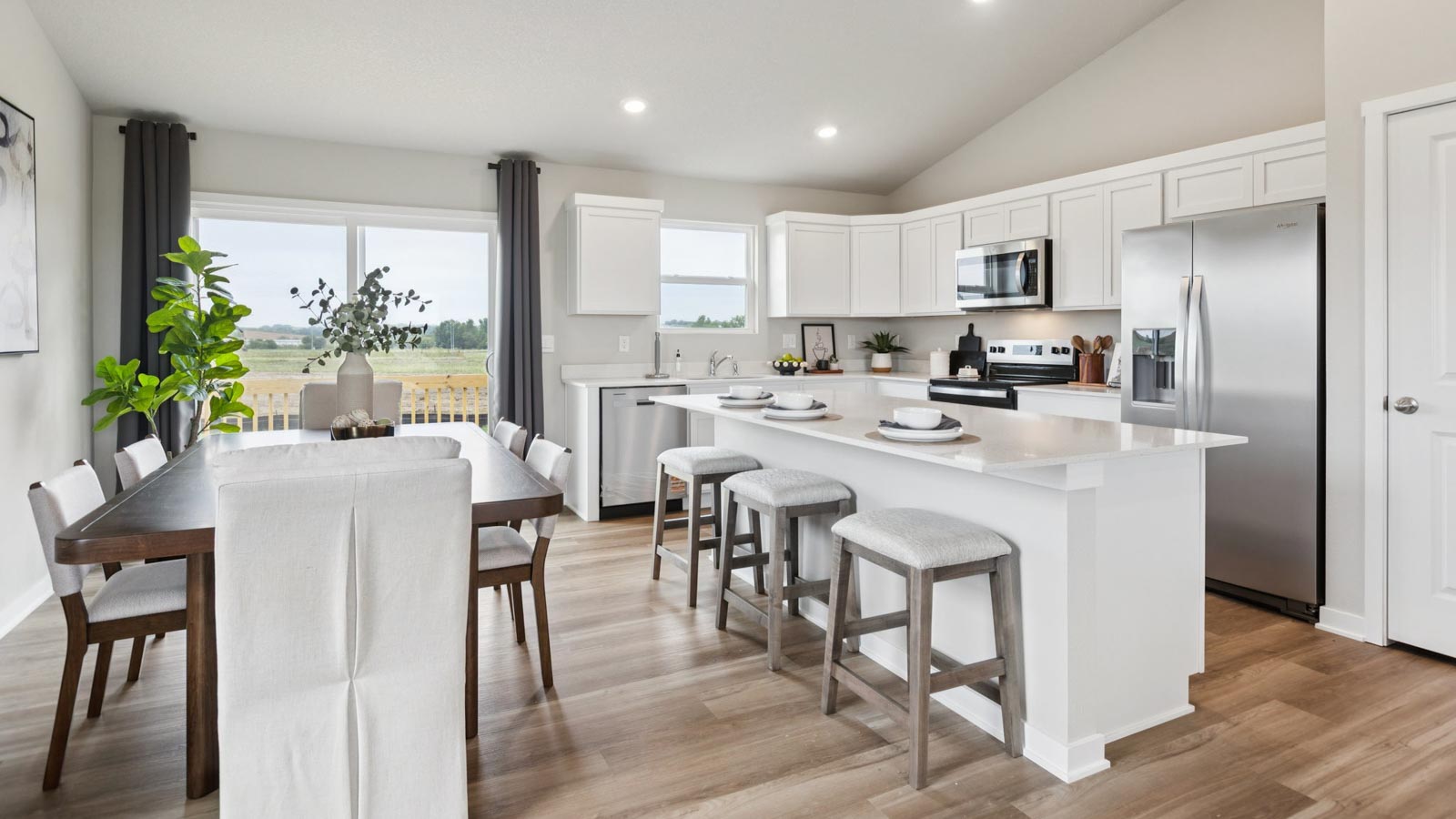 Open concept kitchen area connecting to living and dining space.