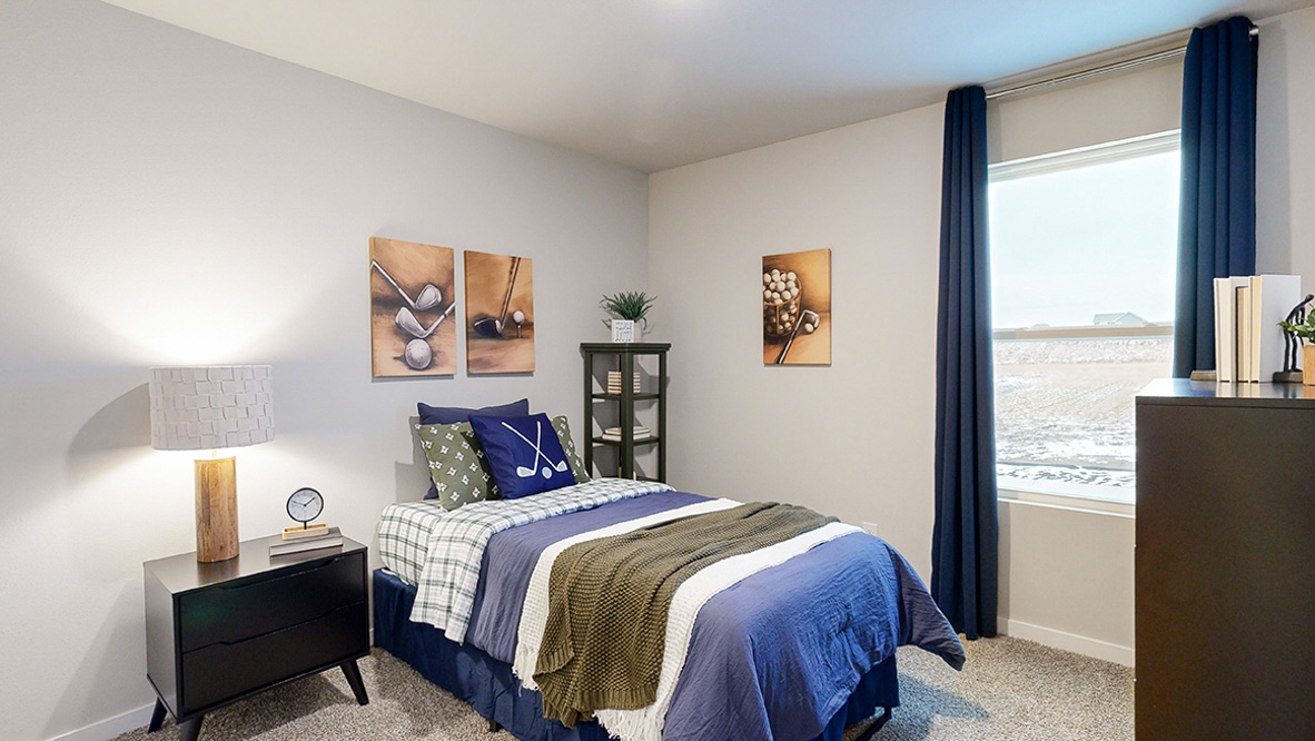 Third bedroom in the Reagan with twin bed and black dresser