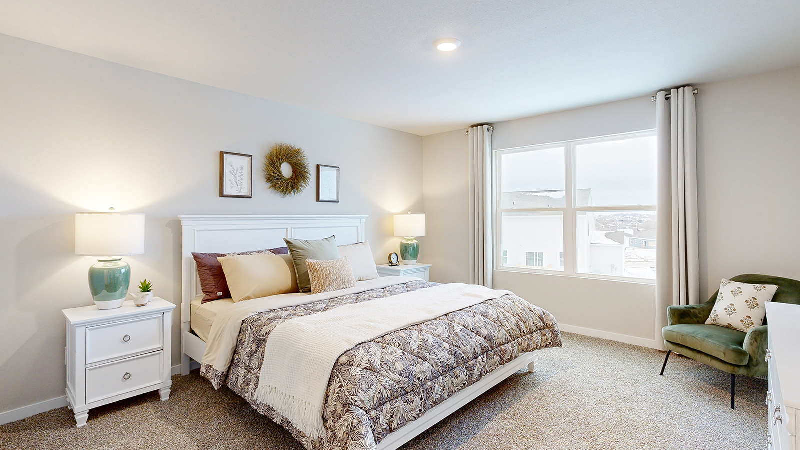 Primary bedroom in the Reagan with a king bed and chair