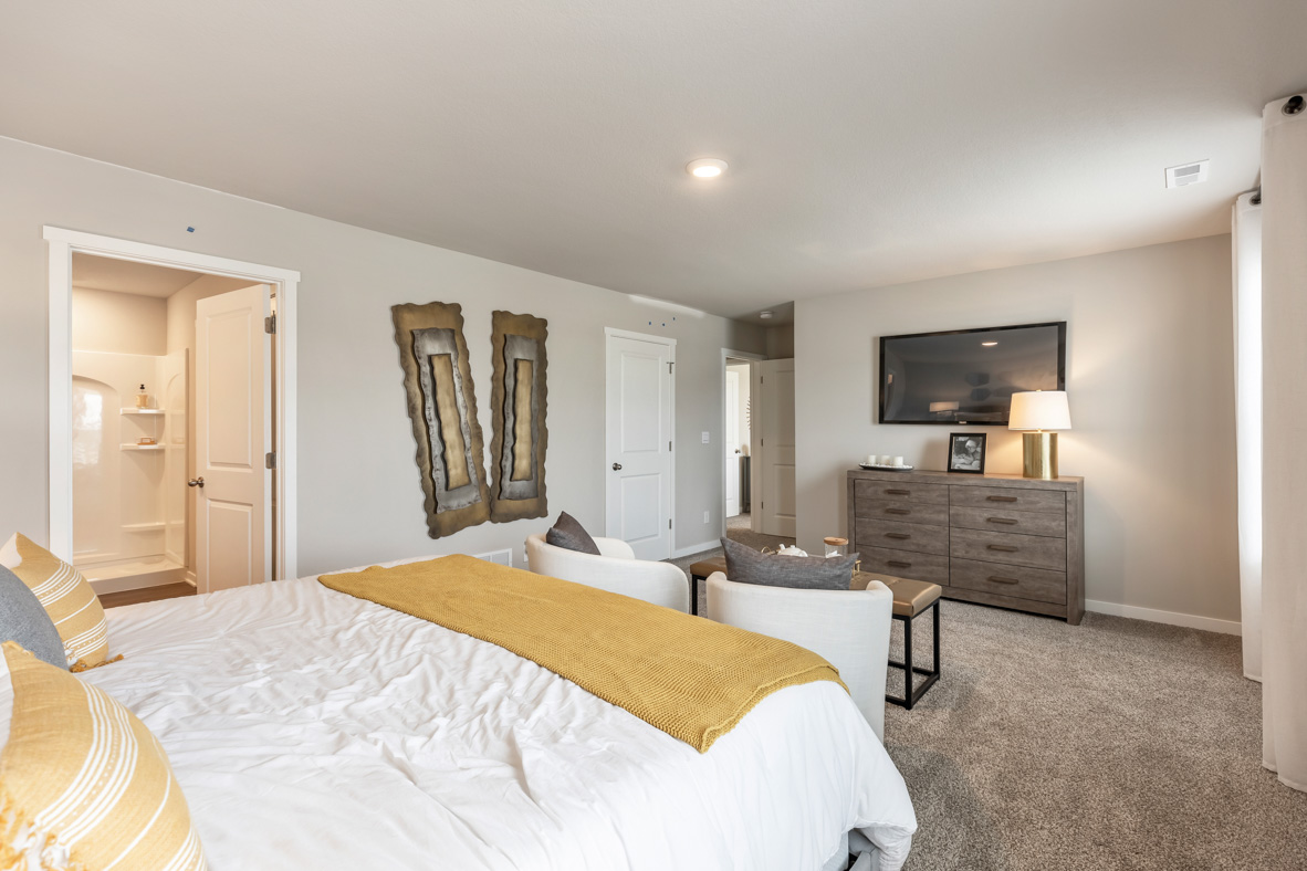 Primary Bedroom with dresser and mounted tv