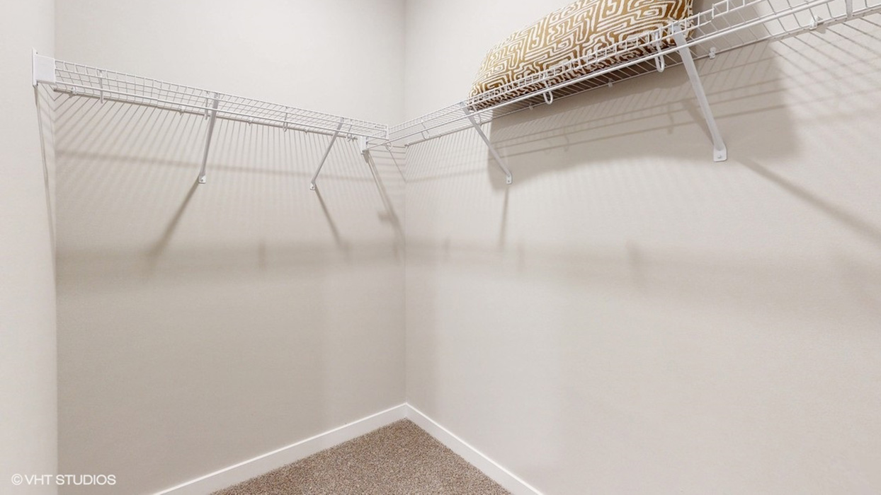 Walk-in closet with shelving off primary bathroom