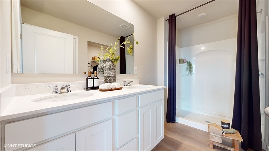 Primary bathroom with white cabinets and shower