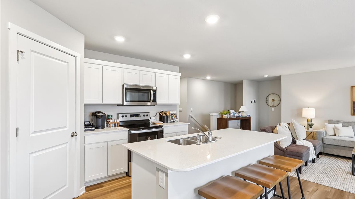 Overview of kitchen of harmony with large kitchen island and barstools for seating