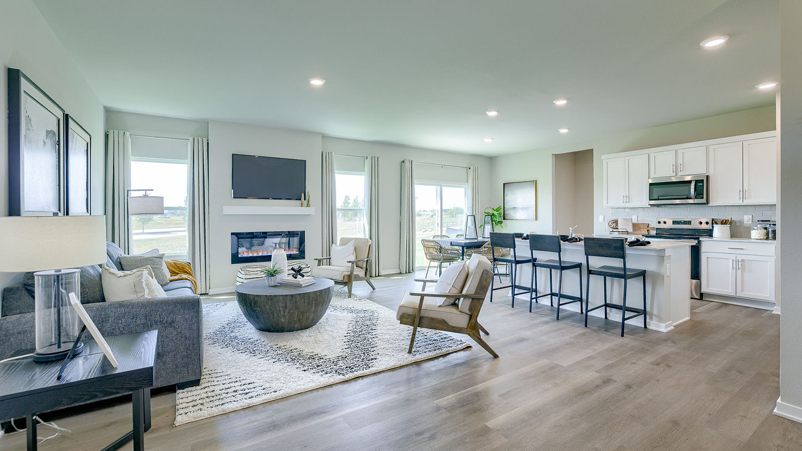 Overview of the Reagan spacious living room and open kitchen with white cabinets