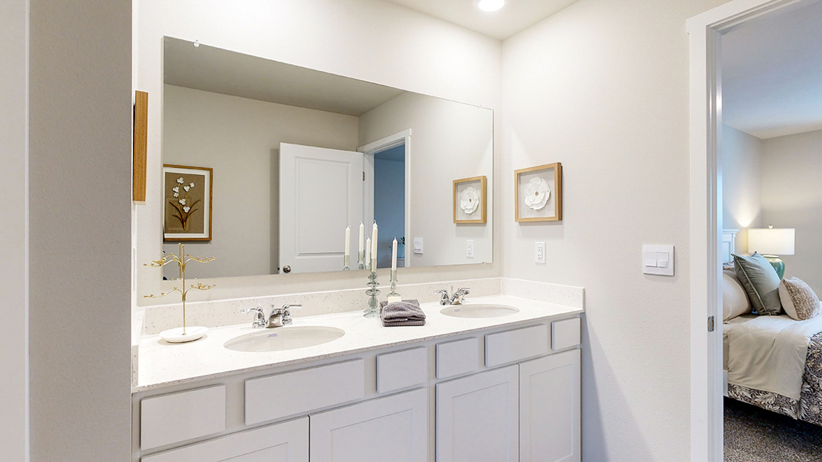 Primary bathroom in the Reagan with dual sinks and white cabinets