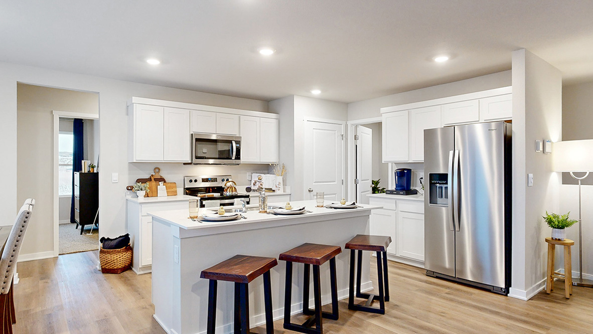 Kitchen of the Reagan with an island and white cabinets