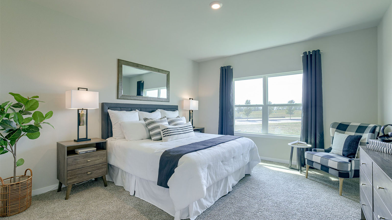 Primary bedroom in the Reagan with a king bed and chair