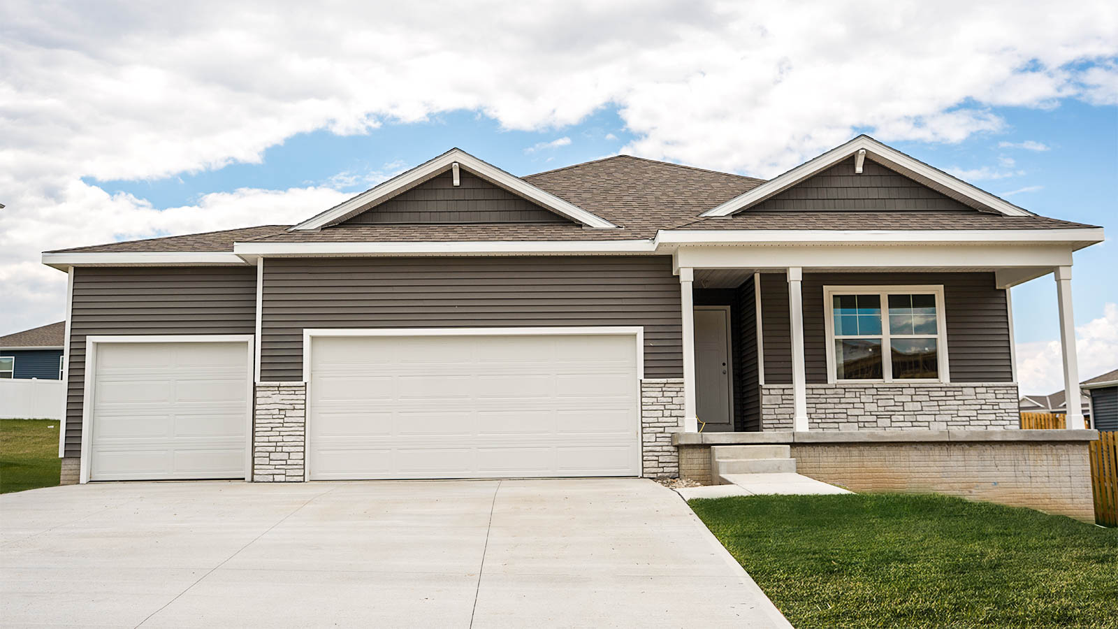 Exterior of Harmony ranch style home with 3 car garage and covered front porch
