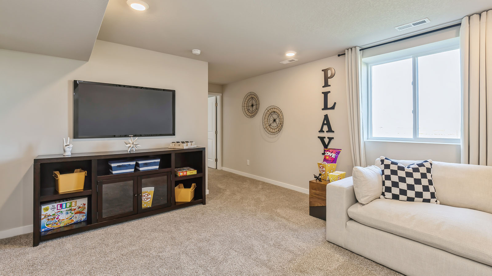 Finished basement with large window and overhead lighting