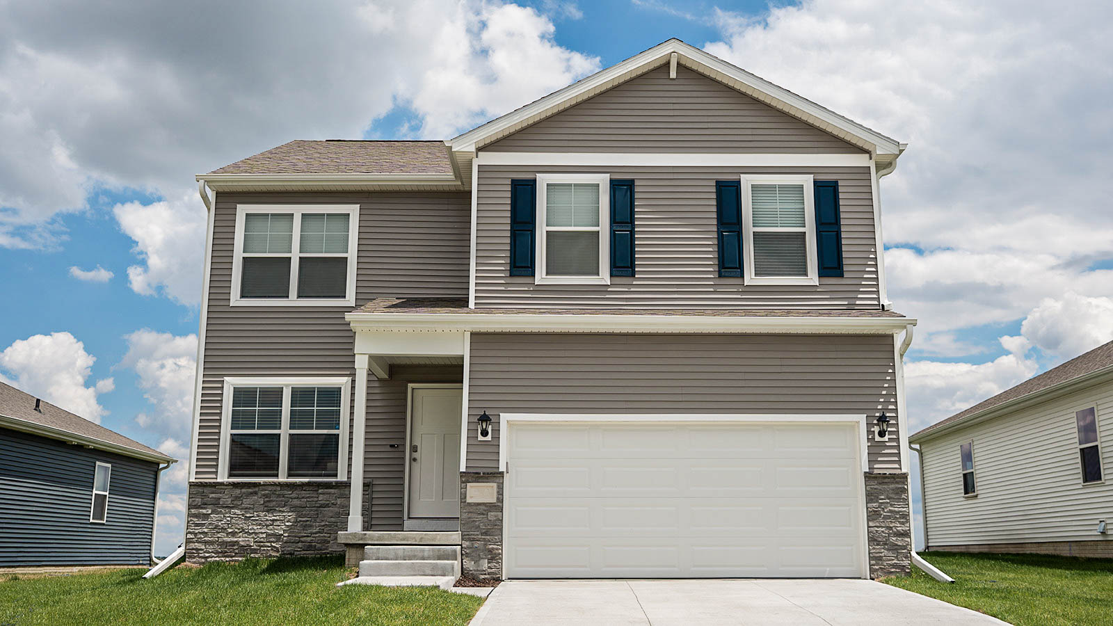 Exterior of Bellhaven, two story floor plan with a 2 car garage and tan siding