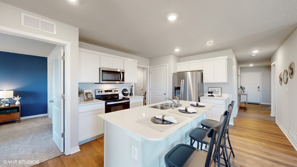 Kitchen with white cabinets stainless steel appliances and an island