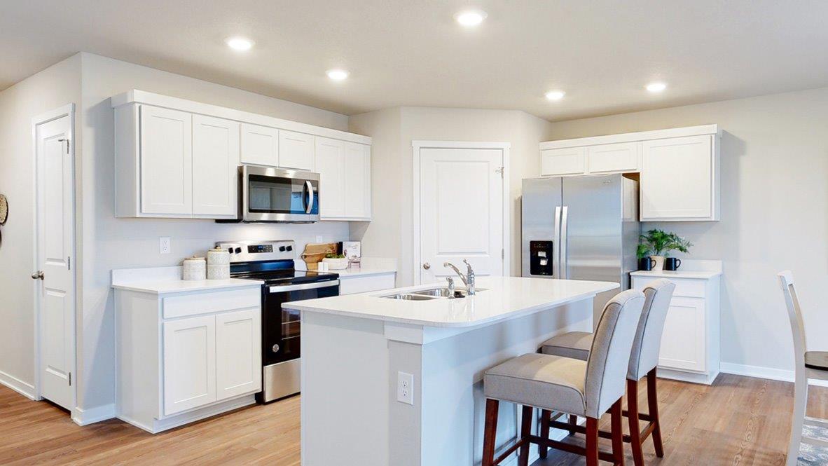 Hamilton Kitchen with white cabinets and an island with 2 chairs