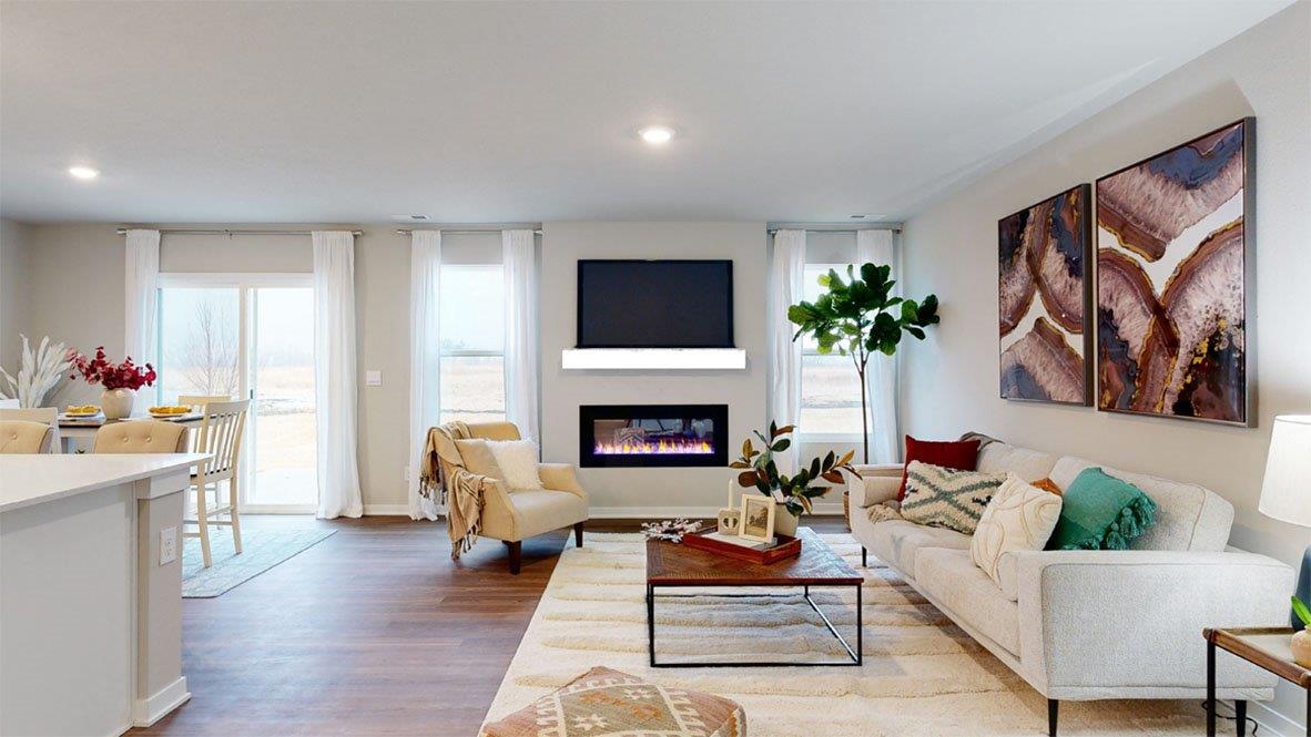 Overview of Hamilton living room with a couch, fireplace, and two large windows
