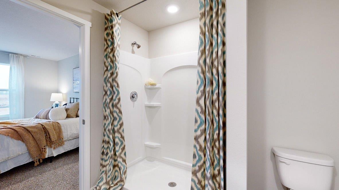 Master bathroom, walk in shower of the hamilton floor plan with colorful shower curtian