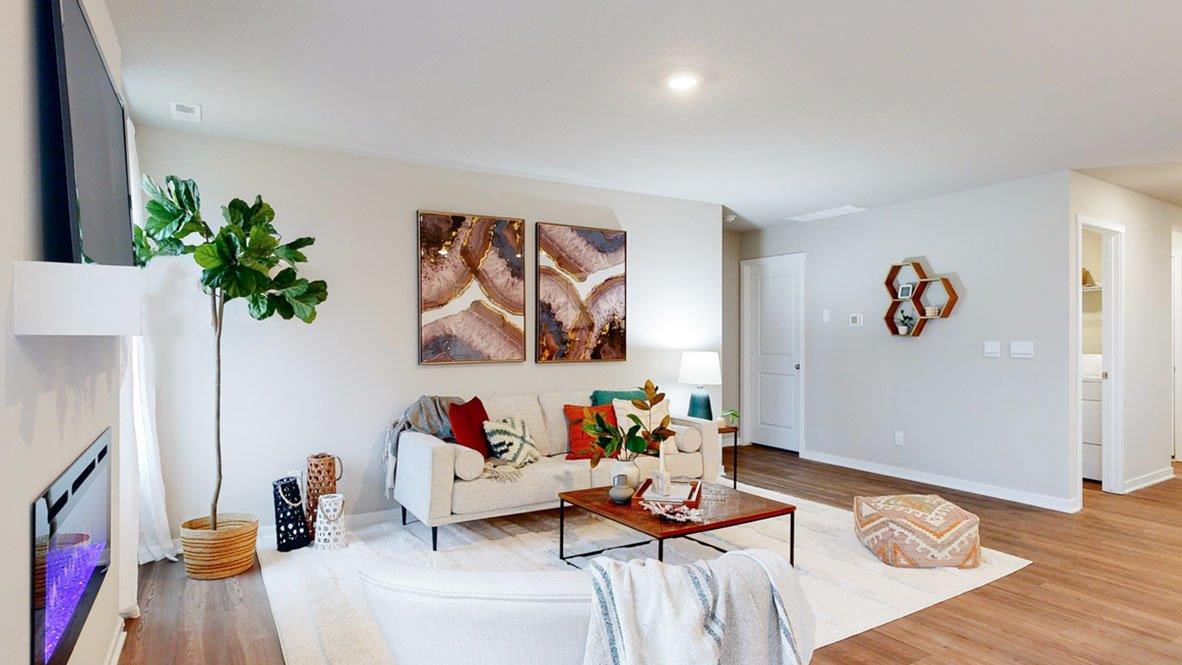 Hamilton living room with a Tv over the fireplace, set up with a couch and an accent chair