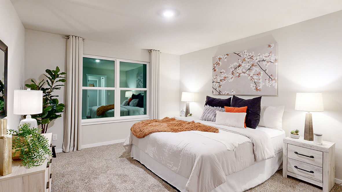 Primary bedroom in the Hamilton with a king bed and white dresser