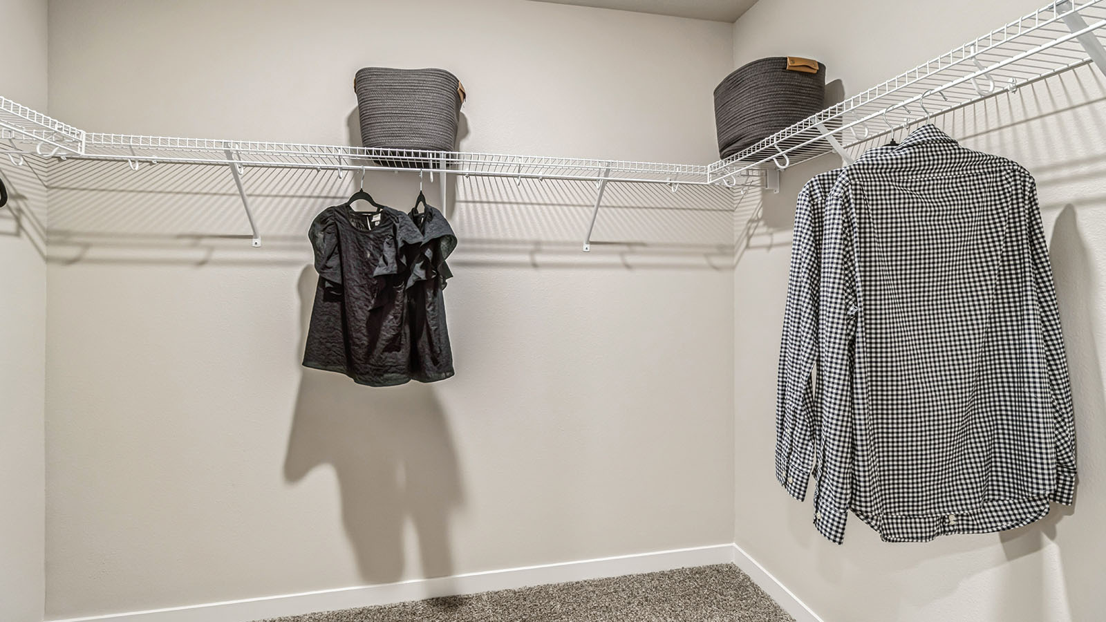 Walk-in closet off primary bedroom with shelving and clothes