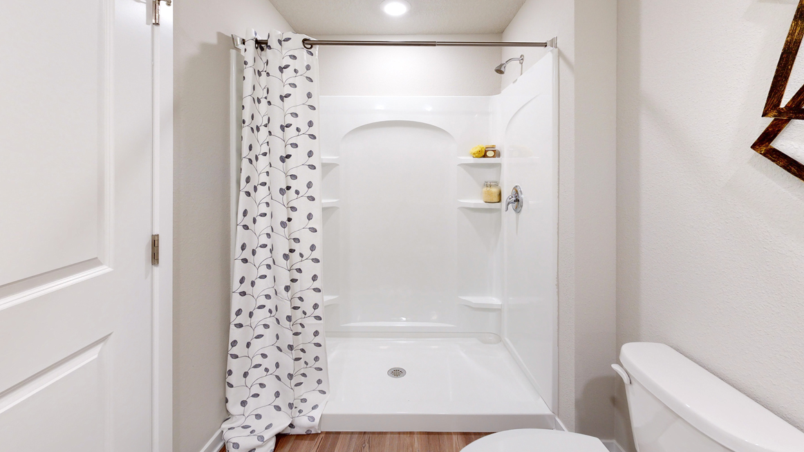 Walk in shower and toilet in the primary bathroom of the Freeport