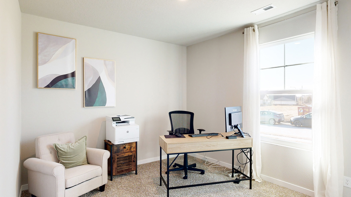 Second bedroom in the Freeport staged as a home office with a desk and 2 chairs