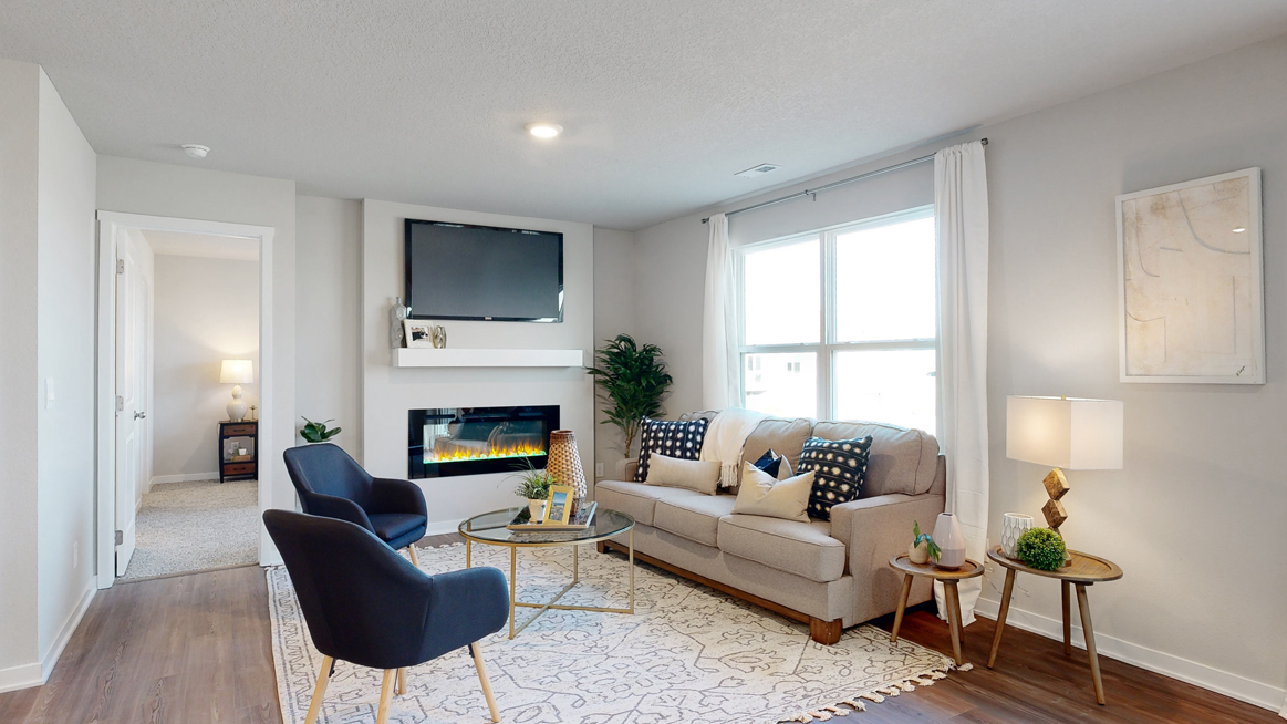 Freeport living room with couch and two chairs showing primary bedroom doorway