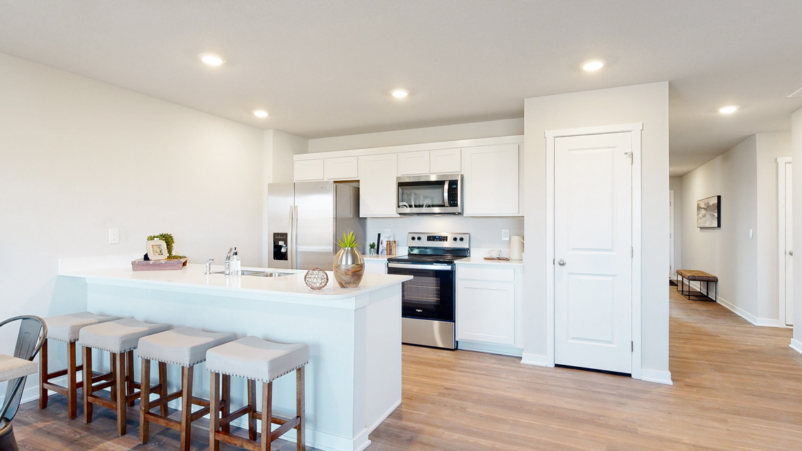 Freeport kitchen showcasing an island white cabinets and pantry door