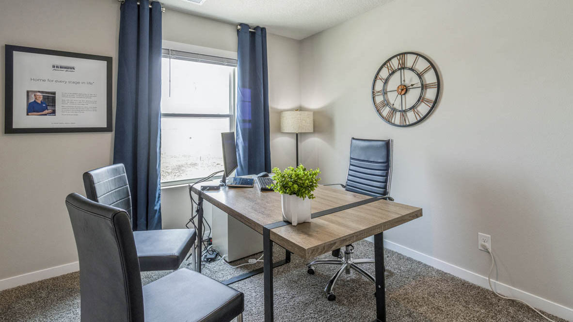 Third bedroom in the Emerson staged as a home office with a desk and chairs