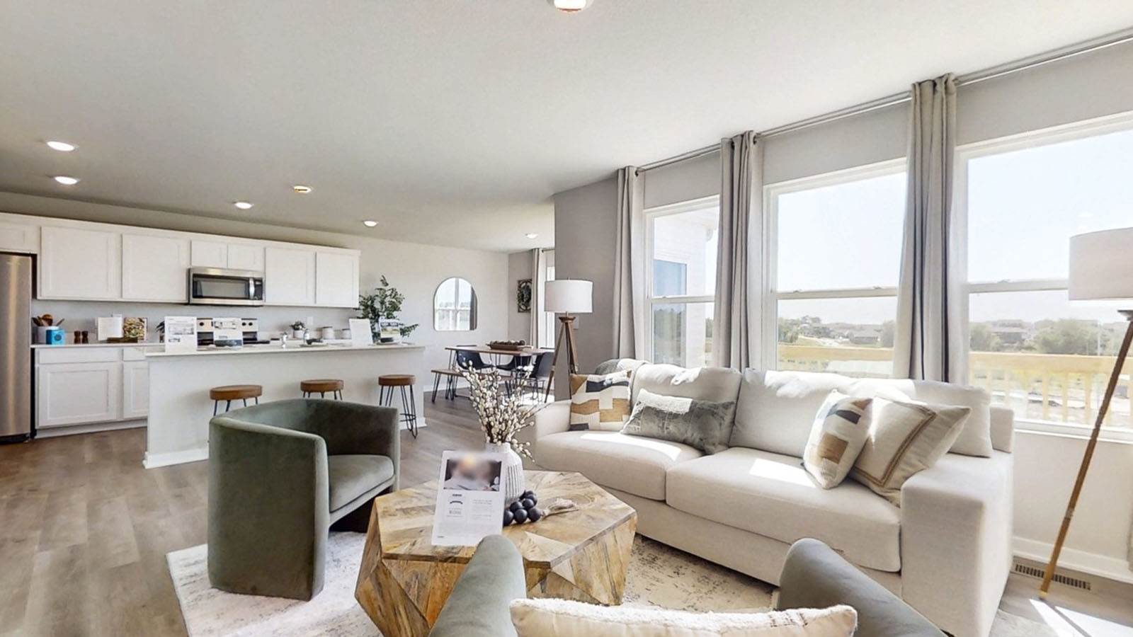 Overview of the Emerson living room showcasing 3 large windows and overlooking the kitchen