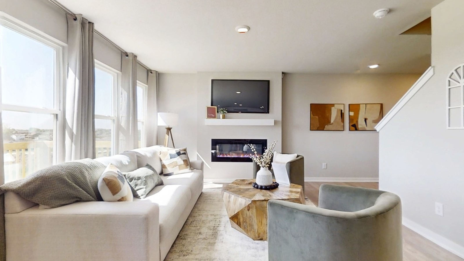 Emerson living room showing the electric fireplace and stairs leading to the second level
