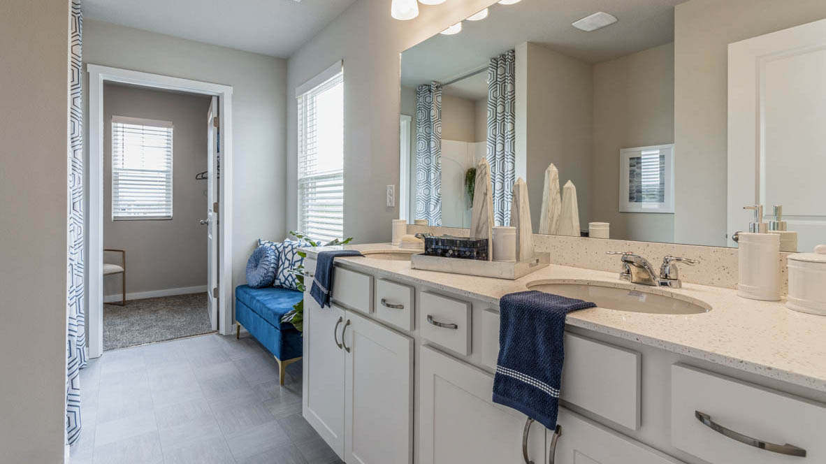 Primary bathroom with white cabinets and dual sinks in the Emerson