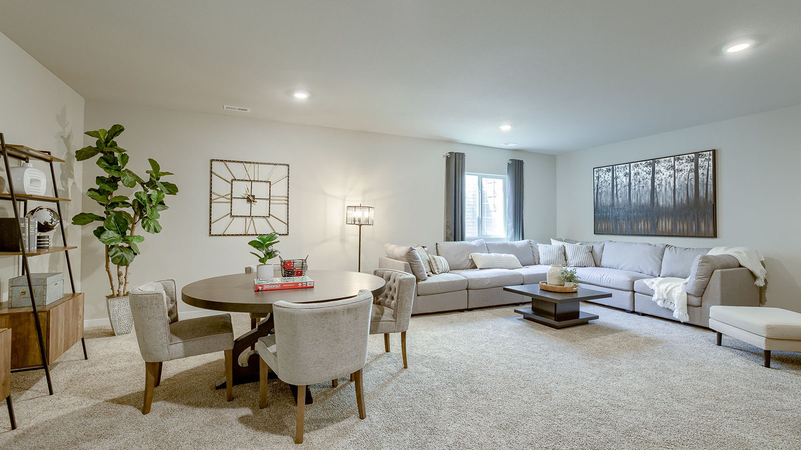 Finished basement in the Reagan with large sectional couch and table and chairs