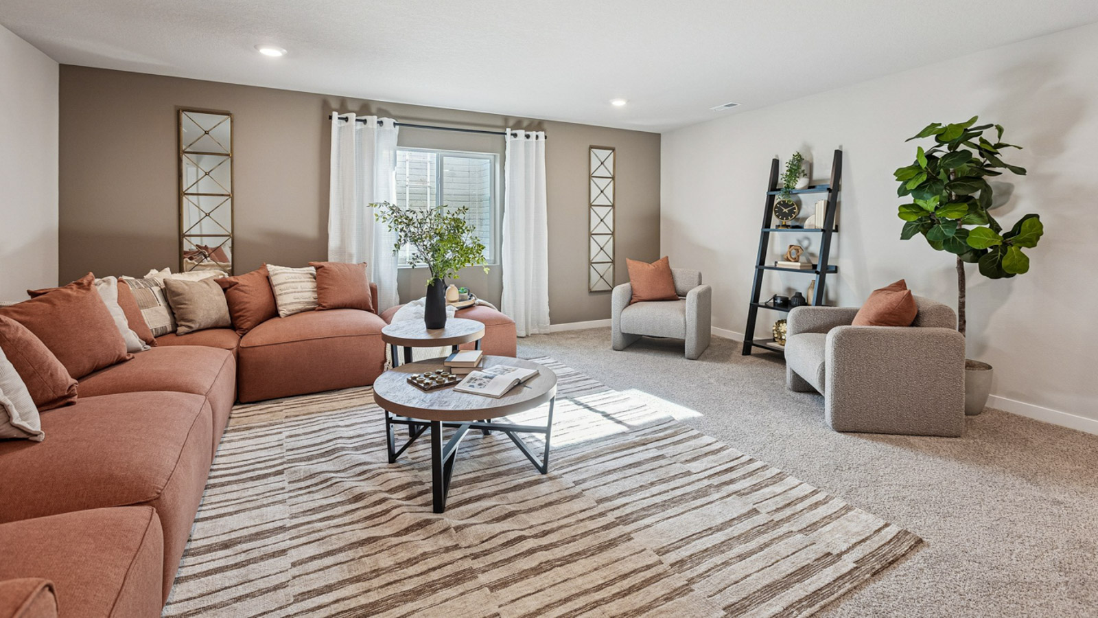 Hamilton finished basement living room with sectional couch and two chairs around a coffee table
