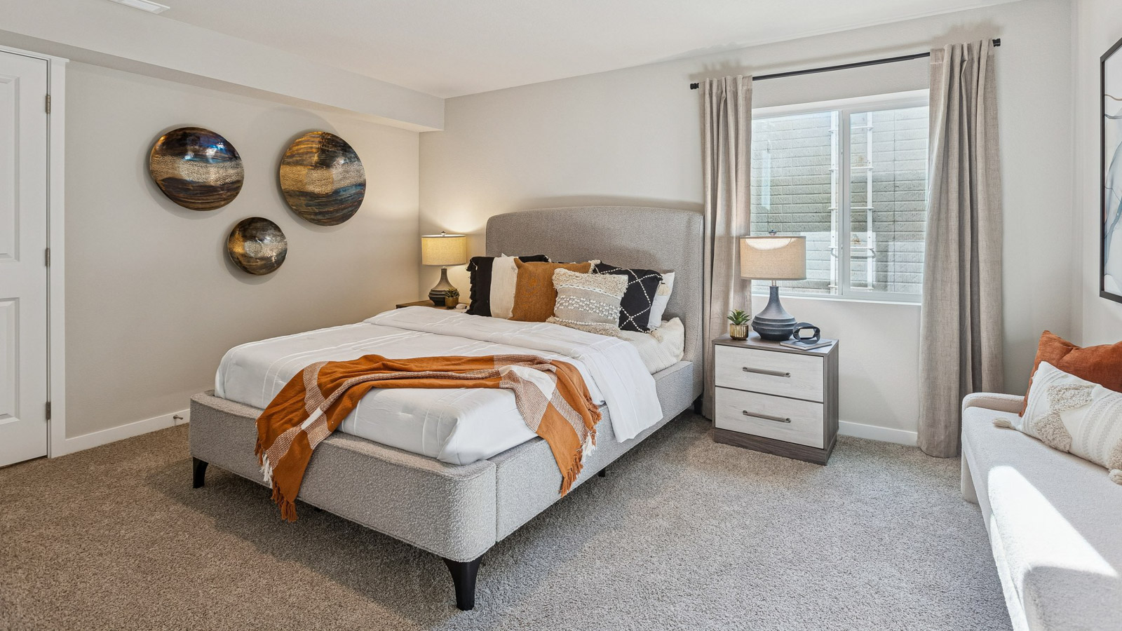 Fourth bedroom in the Hamilton finished basement with full bed and sitting bench