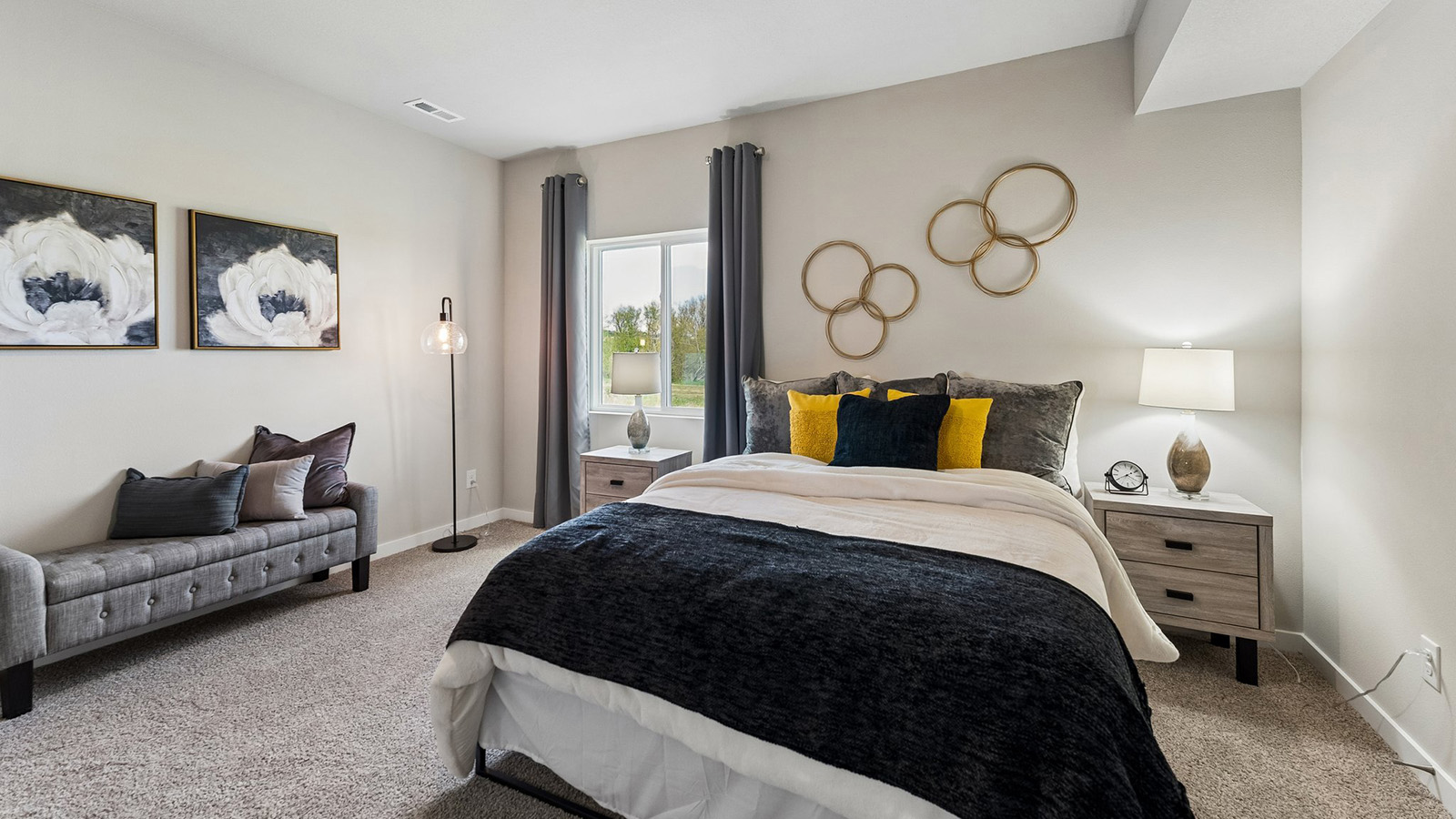 Fourth bedroom in the Hamilton finished basement with queen bed and sitting bench