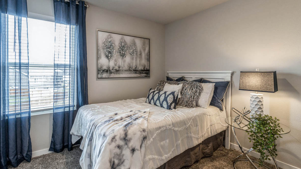 Second bedroom in the Edmon with a full bed large window and nightstand