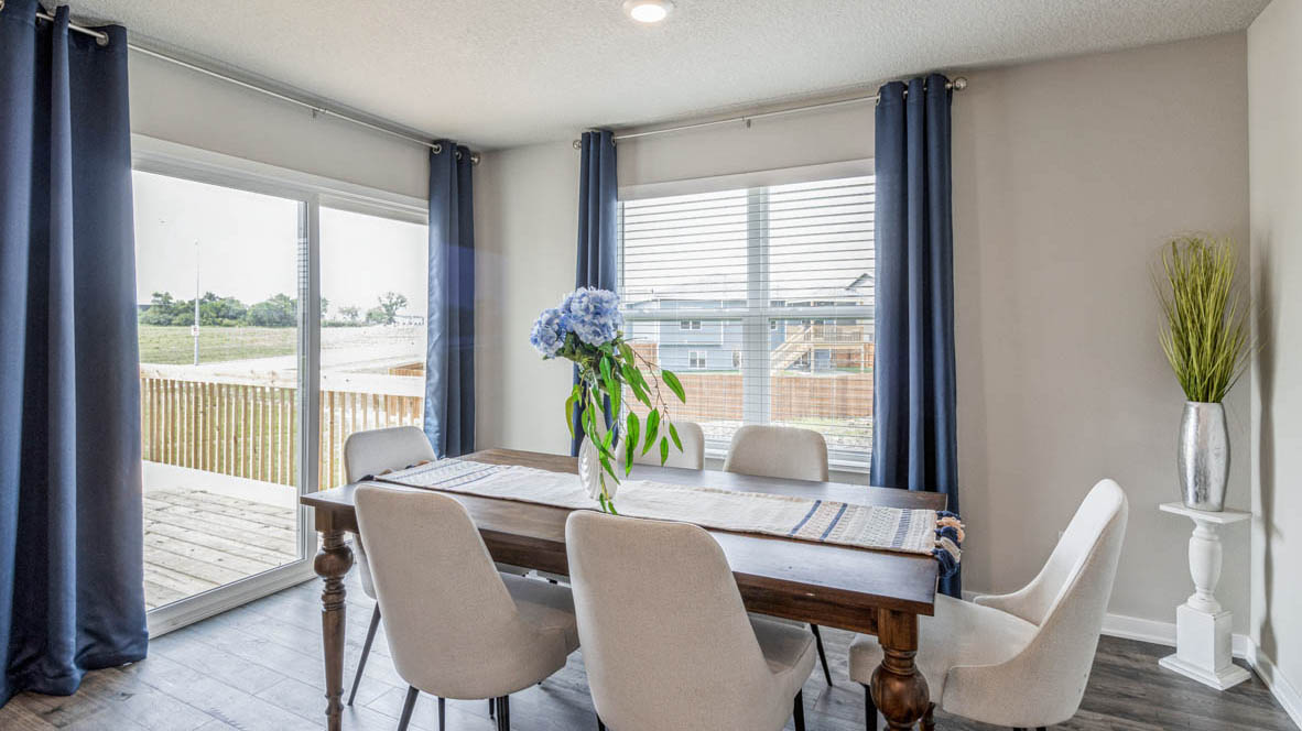 Bright dining area with large window and sliding glass doors leading to the deck in the Edmon